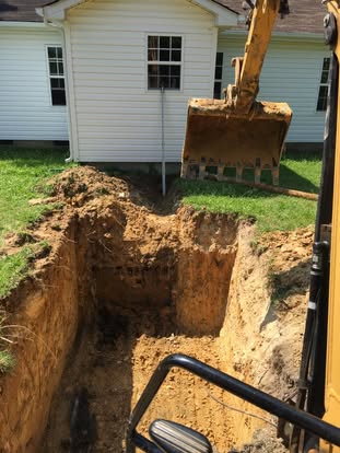 Excavator opening a tank hole beside a Union County home