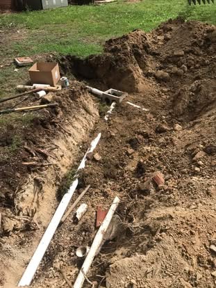 Drain field trench with pipe and D-box