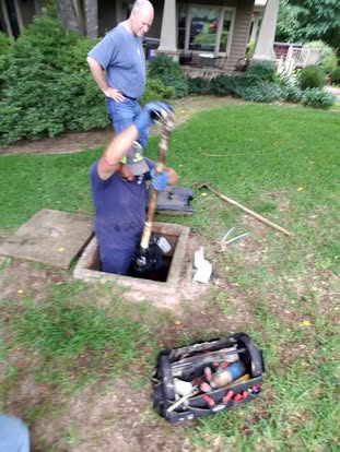 Technician working in an open tank on a pump and alarm call