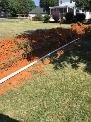 New drain line in red clay on a residential septic job